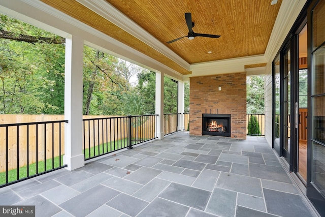 view of patio / terrace featuring ceiling fan and an outdoor brick fireplace