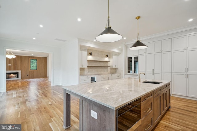 kitchen featuring wine cooler, sink, white cabinets, and a spacious island