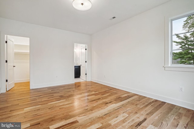 empty room with light hardwood / wood-style floors and a wealth of natural light