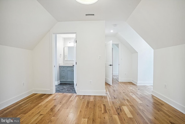 additional living space featuring light hardwood / wood-style floors and lofted ceiling