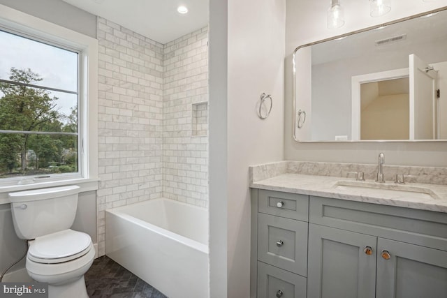 full bathroom with vanity, toilet, and tiled shower / bath