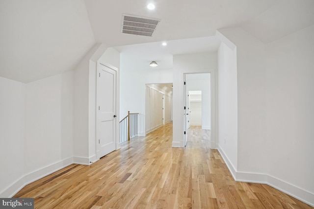 additional living space with light hardwood / wood-style flooring and vaulted ceiling