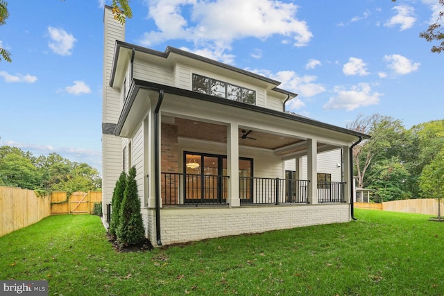 back of property featuring a lawn and ceiling fan