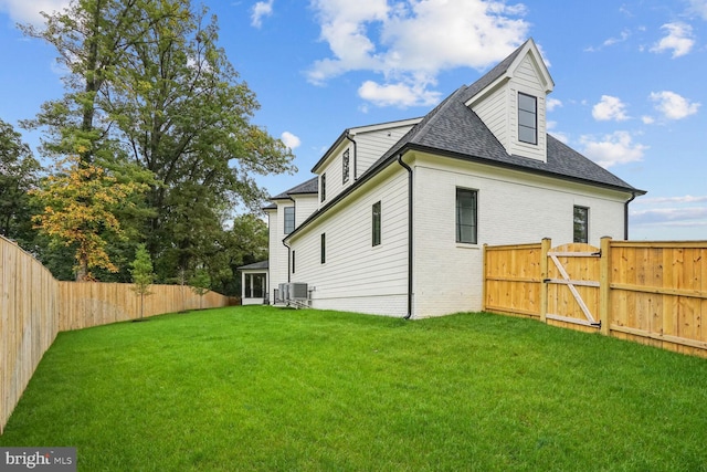 rear view of property featuring cooling unit and a lawn