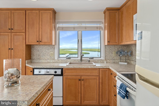 kitchen featuring backsplash, sink, and white appliances