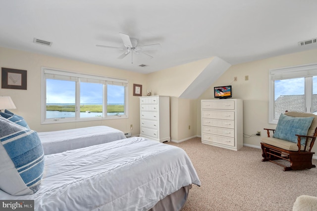 bedroom with light carpet, multiple windows, a water view, and ceiling fan