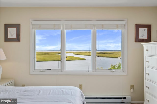 bedroom with a baseboard heating unit, multiple windows, and a water view