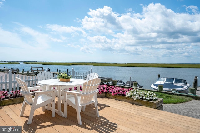 wooden terrace featuring a dock and a water view