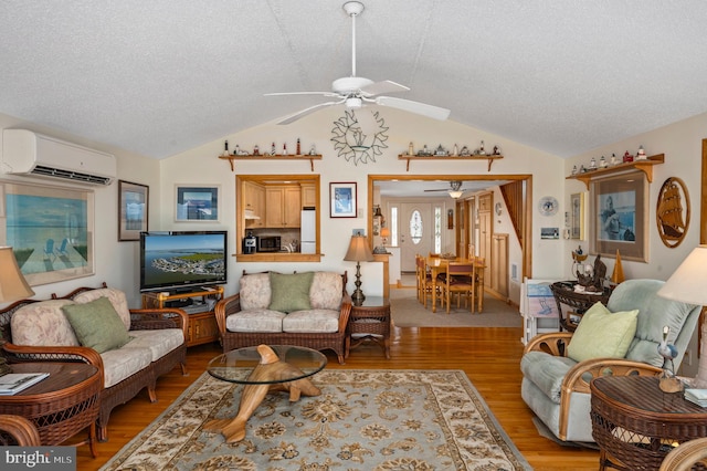 living room featuring a textured ceiling, a wall mounted AC, hardwood / wood-style flooring, and vaulted ceiling