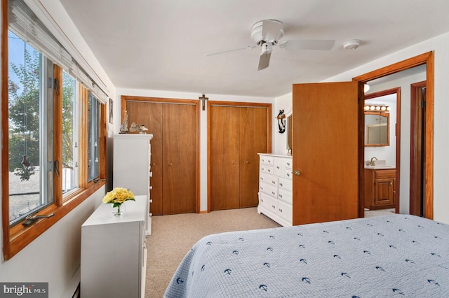 carpeted bedroom featuring two closets and ceiling fan