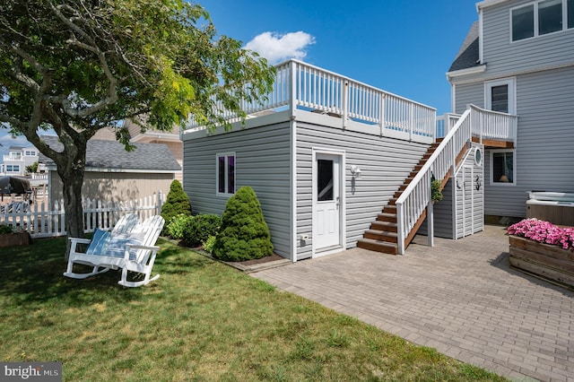 rear view of house with a patio, a deck, and a lawn