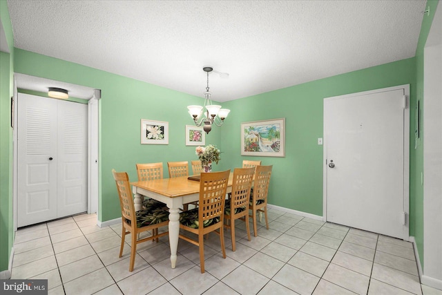 dining area featuring a notable chandelier, a textured ceiling, and light tile patterned floors