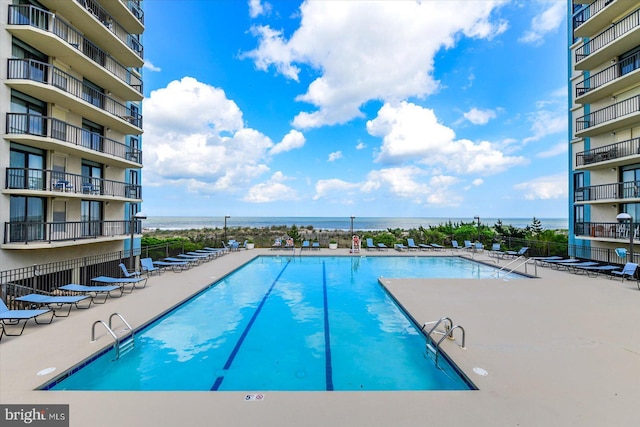 view of swimming pool with a water view and a patio area