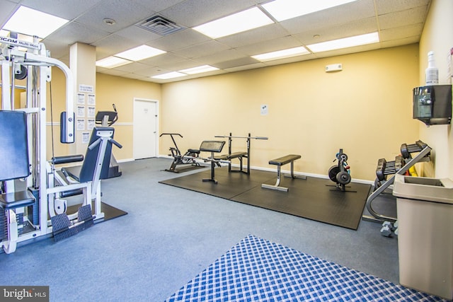 workout area featuring carpet and a paneled ceiling