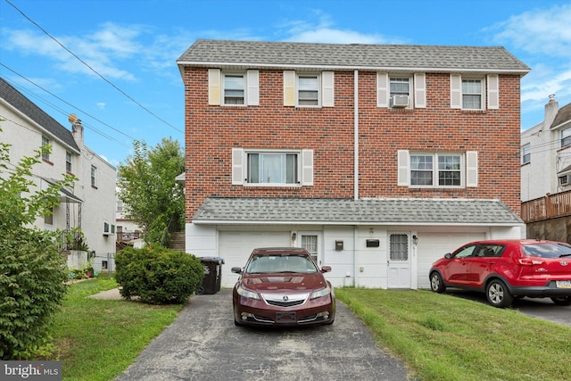 view of front of house with cooling unit, a garage, and a front yard