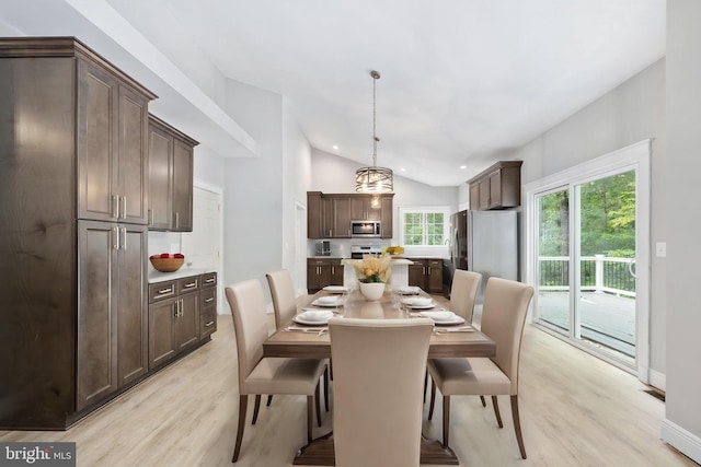 dining room with light hardwood / wood-style flooring and vaulted ceiling