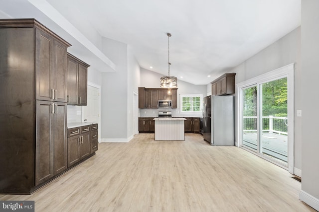 kitchen with dark brown cabinetry, hanging light fixtures, light hardwood / wood-style flooring, appliances with stainless steel finishes, and vaulted ceiling