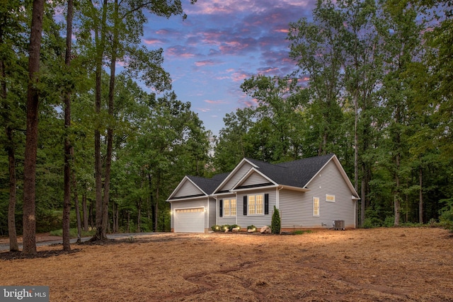 view of front of home with central AC unit and a garage