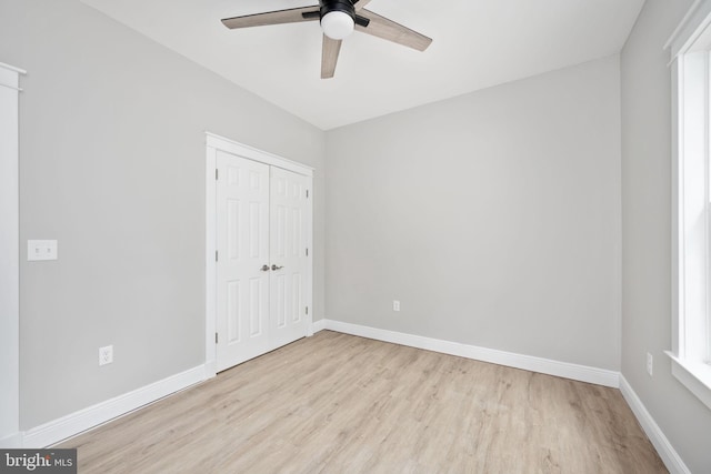 unfurnished bedroom featuring light hardwood / wood-style floors, ceiling fan, and a closet