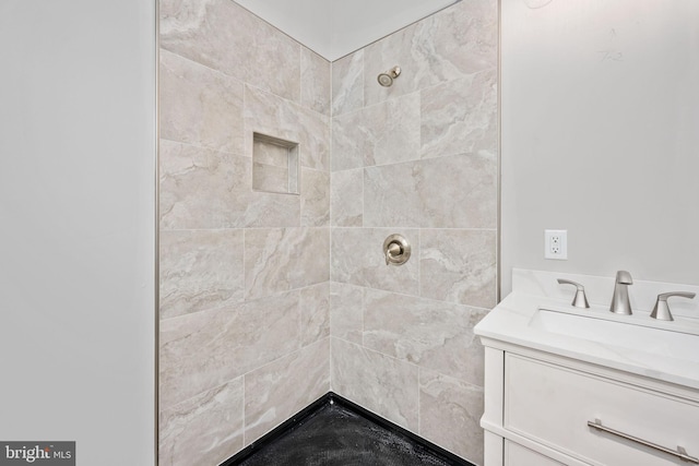 bathroom featuring a tile shower and vanity