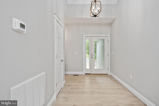 foyer with light hardwood / wood-style flooring and a notable chandelier