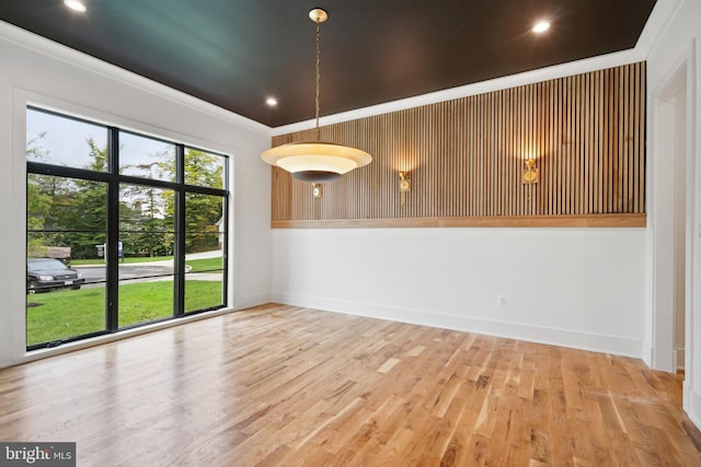 spare room with recessed lighting, crown molding, baseboards, and wood finished floors