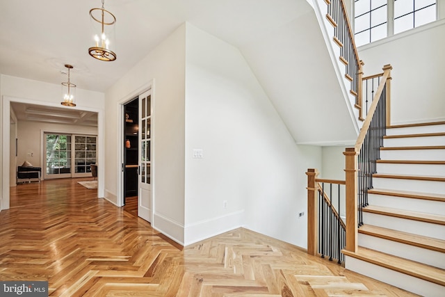 stairs featuring parquet flooring and a chandelier