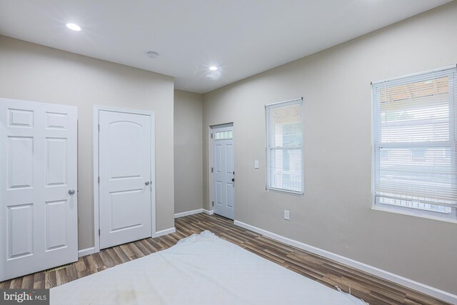 bedroom with multiple windows and hardwood / wood-style flooring