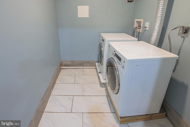 washroom with light tile patterned floors and washer and dryer