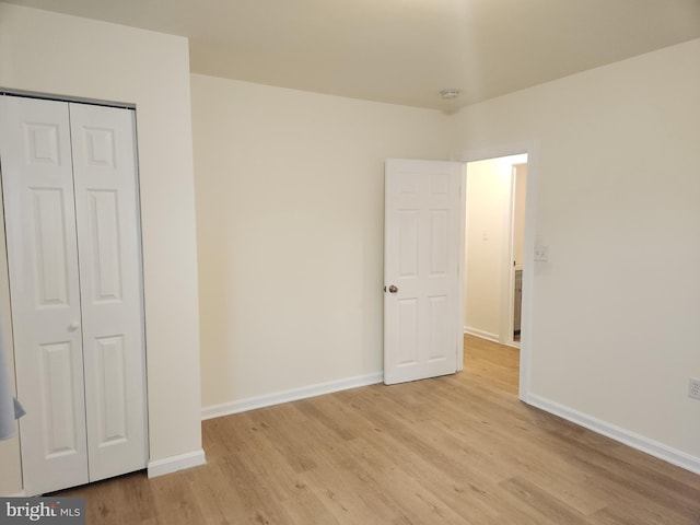 unfurnished bedroom featuring light hardwood / wood-style floors and a closet