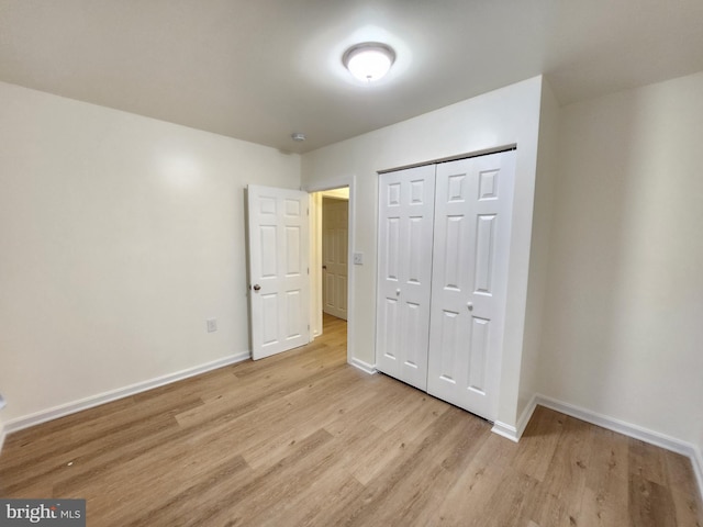 unfurnished bedroom featuring a closet and light hardwood / wood-style floors