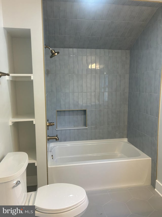 full bath with tile patterned floors, toilet, and washtub / shower combination