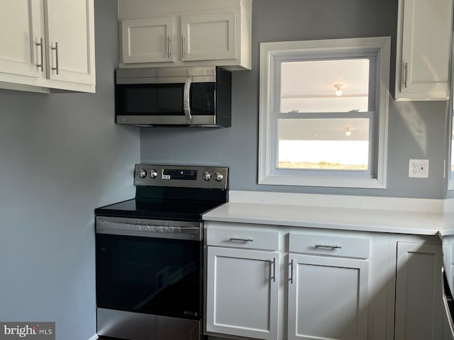 kitchen with sink, stainless steel refrigerator, dark hardwood / wood-style flooring, and white cabinetry