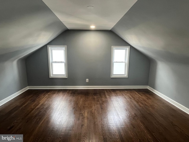 hall with lofted ceiling and hardwood / wood-style flooring