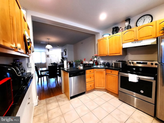 kitchen featuring sink, stainless steel appliances, decorative light fixtures, and light tile patterned floors