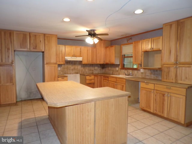 kitchen featuring a kitchen island, sink, backsplash, light tile patterned floors, and ceiling fan