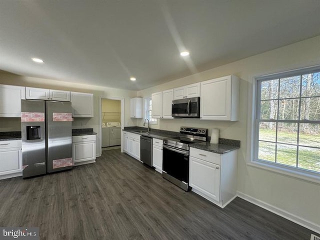 kitchen with white cabinetry, a healthy amount of sunlight, appliances with stainless steel finishes, and washer and clothes dryer