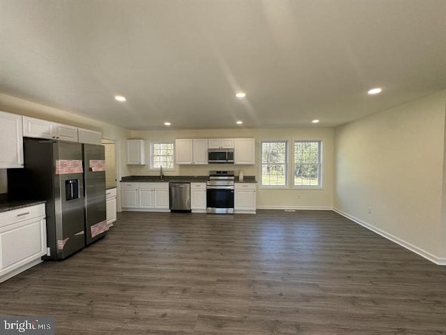 kitchen featuring stainless steel appliances, sink, white cabinetry, dark hardwood / wood-style flooring, and a healthy amount of sunlight