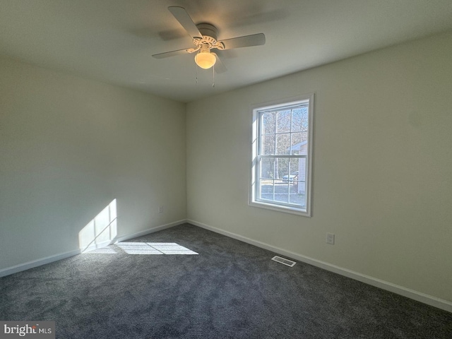 empty room with dark colored carpet and ceiling fan