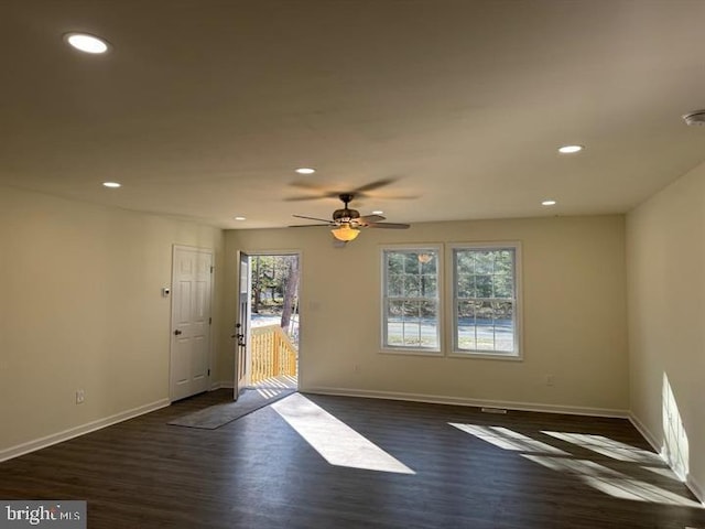 empty room with dark hardwood / wood-style flooring and ceiling fan