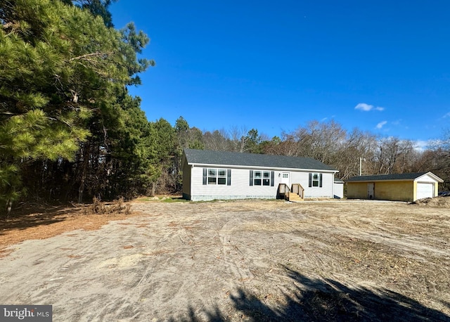 view of front facade featuring a garage and an outbuilding