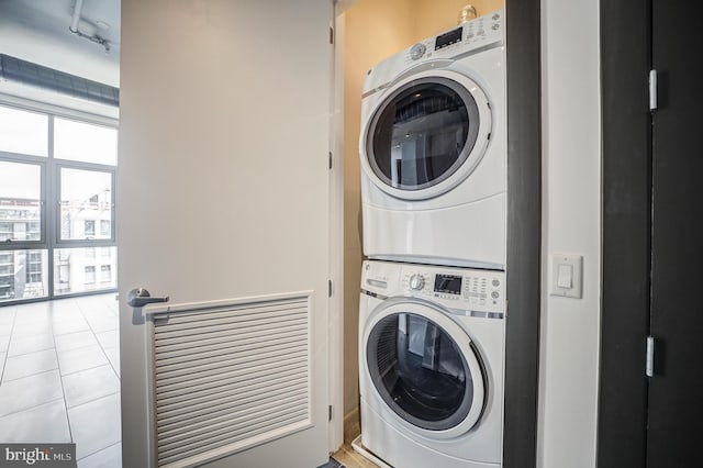 washroom featuring light tile patterned flooring and stacked washer and clothes dryer