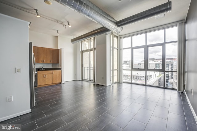 interior space with a wealth of natural light, rail lighting, and floor to ceiling windows