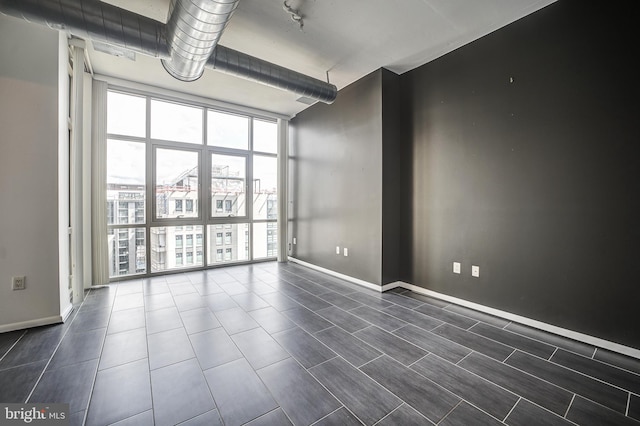 empty room featuring a wall of windows and a wealth of natural light