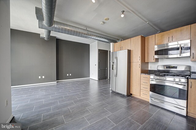 kitchen featuring appliances with stainless steel finishes and dark tile patterned flooring