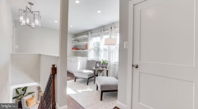 living area with wood-type flooring and a chandelier