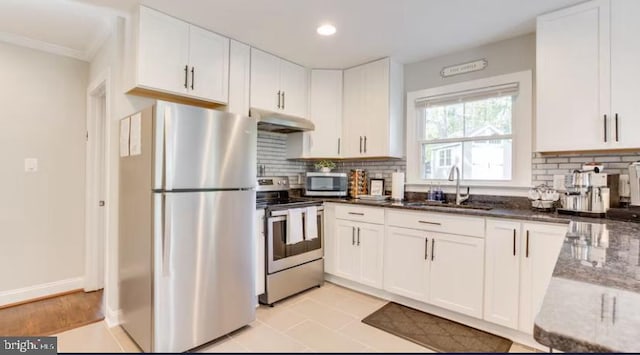 kitchen featuring white cabinetry, tasteful backsplash, light tile patterned floors, stainless steel appliances, and sink