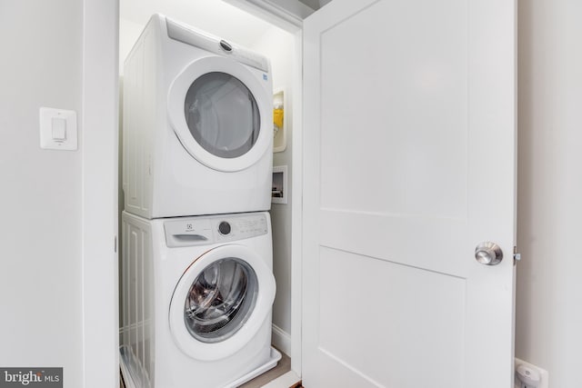 washroom featuring stacked washer and clothes dryer