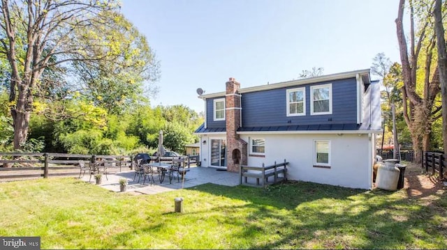 rear view of property featuring a yard and a patio area