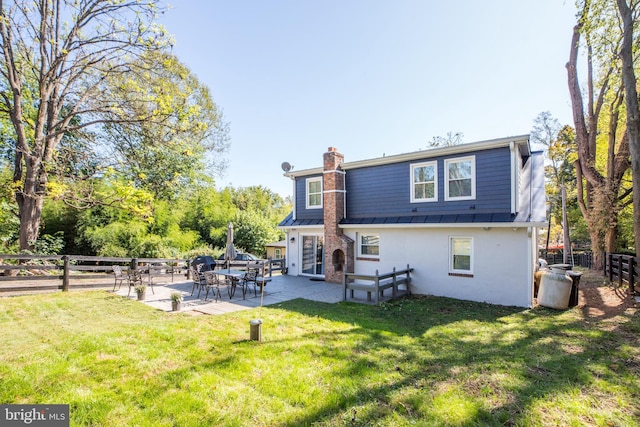 rear view of property with a patio and a yard